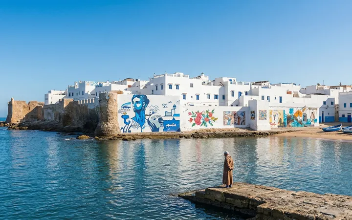 White lane adorned with colourful murals in the medina of Asilah